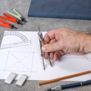 cropped-hand-drawing-paper-with-compass