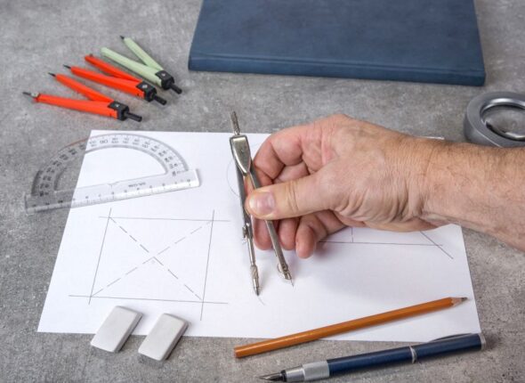 cropped-hand-drawing-paper-with-compass